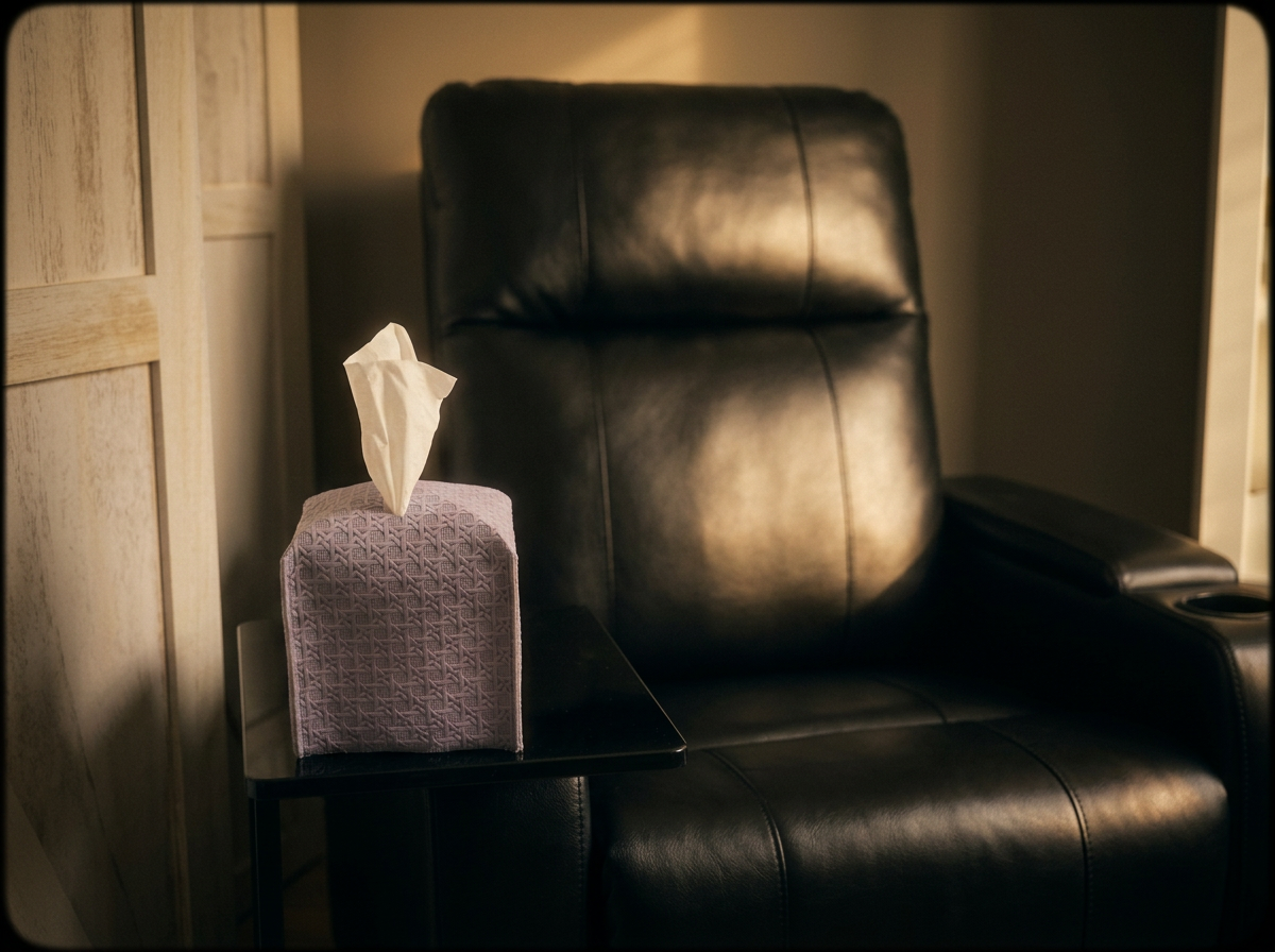 Black leather recliner in a Spravato® suite with a lavender tissue box on a side table, bathed in soft warm window light.
